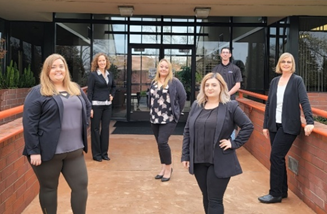 A group of women standing outside a building

Description automatically generated